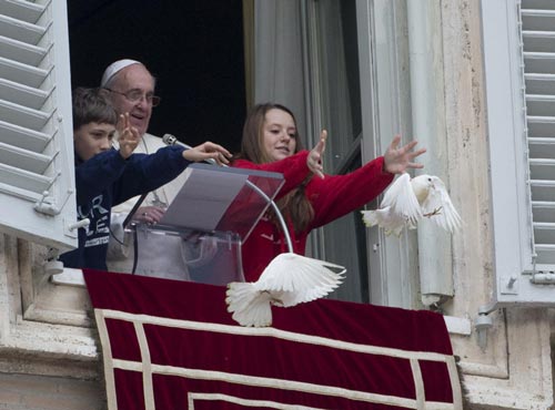 طفل وطفلة يطلقان حمام السلام من نافذة القصر بالفاتيكان