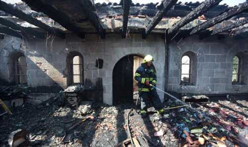 رجل اطفاء يخمد النار في كنيسة الطابغة