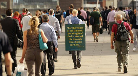 رجل يعلق على ظهره لافتة تروج للمسيحية في لندن أغسطس/الماضي.